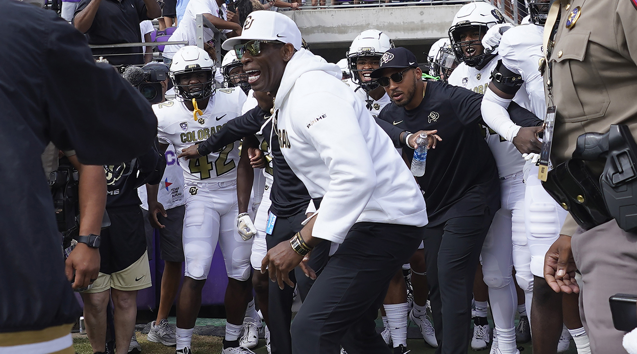 Colorado coach Deion Sanders runs onto the field with his team for a an NCAA college football game against TCU.